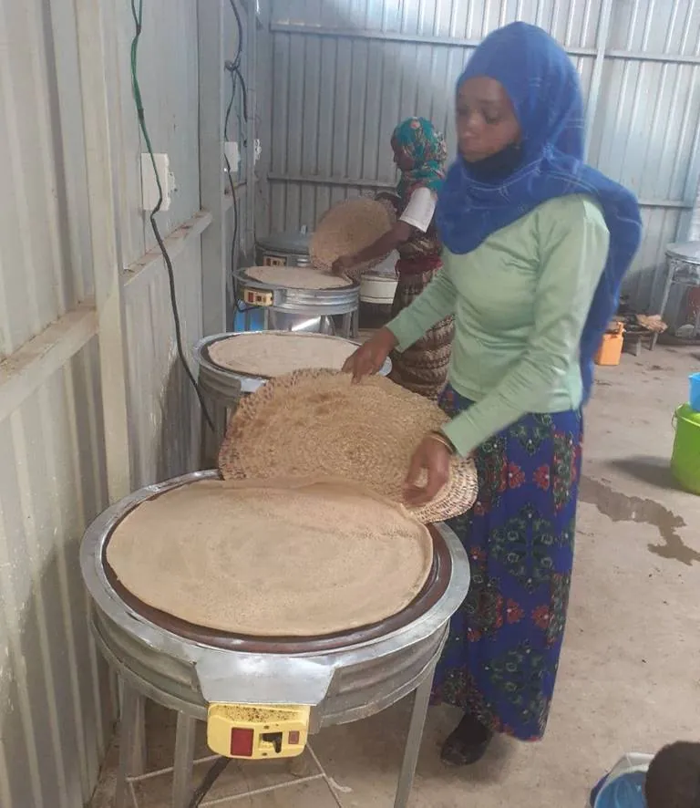 A woman cooking injera in a small food business.