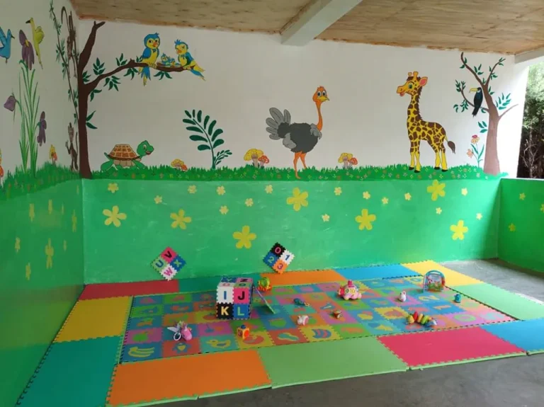 A brightly painted children’s play room with colourful foam floor mats.